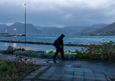 Lone walker on a stormy morning in Ísafjörður